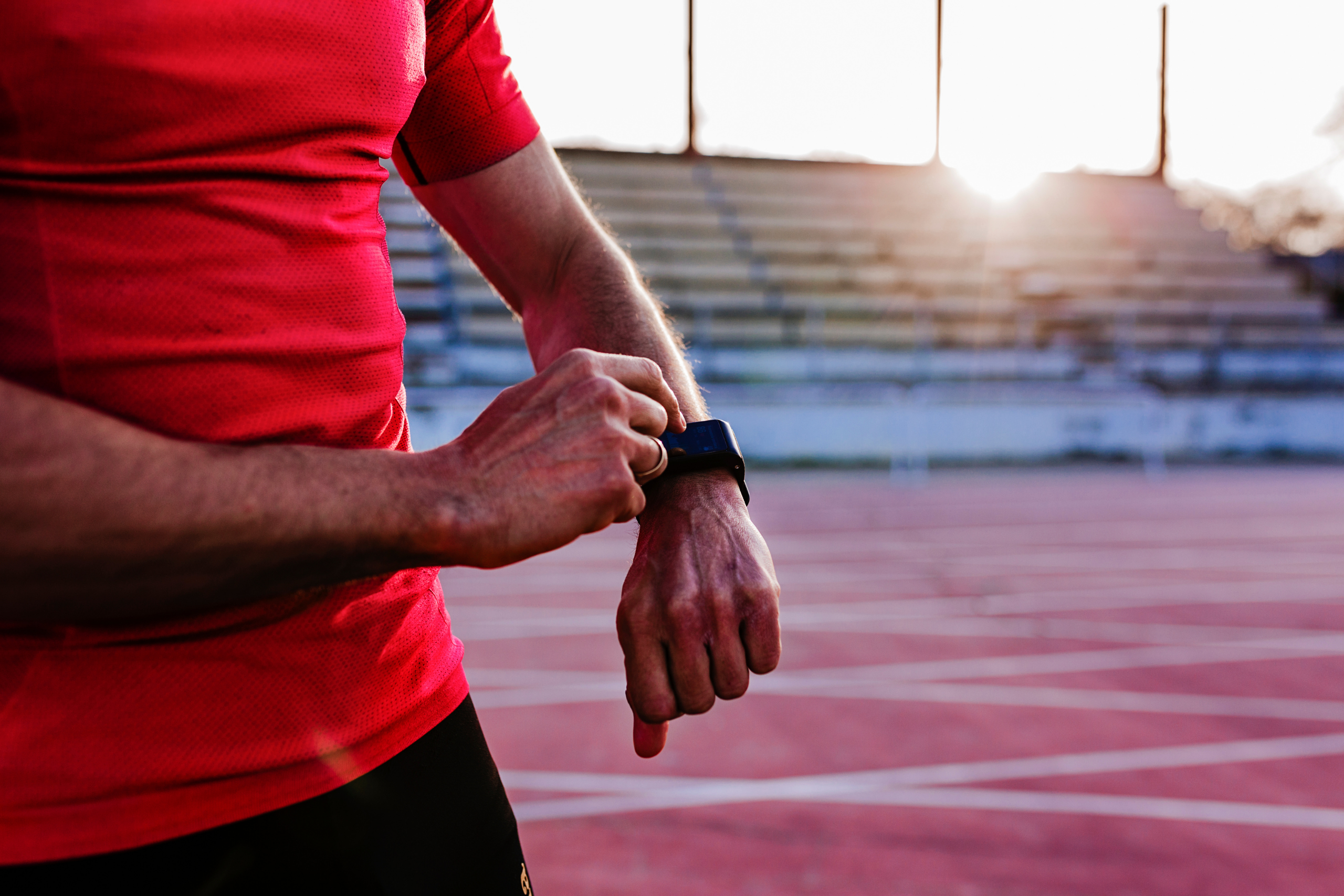 Active man using peptide therapy checking watch